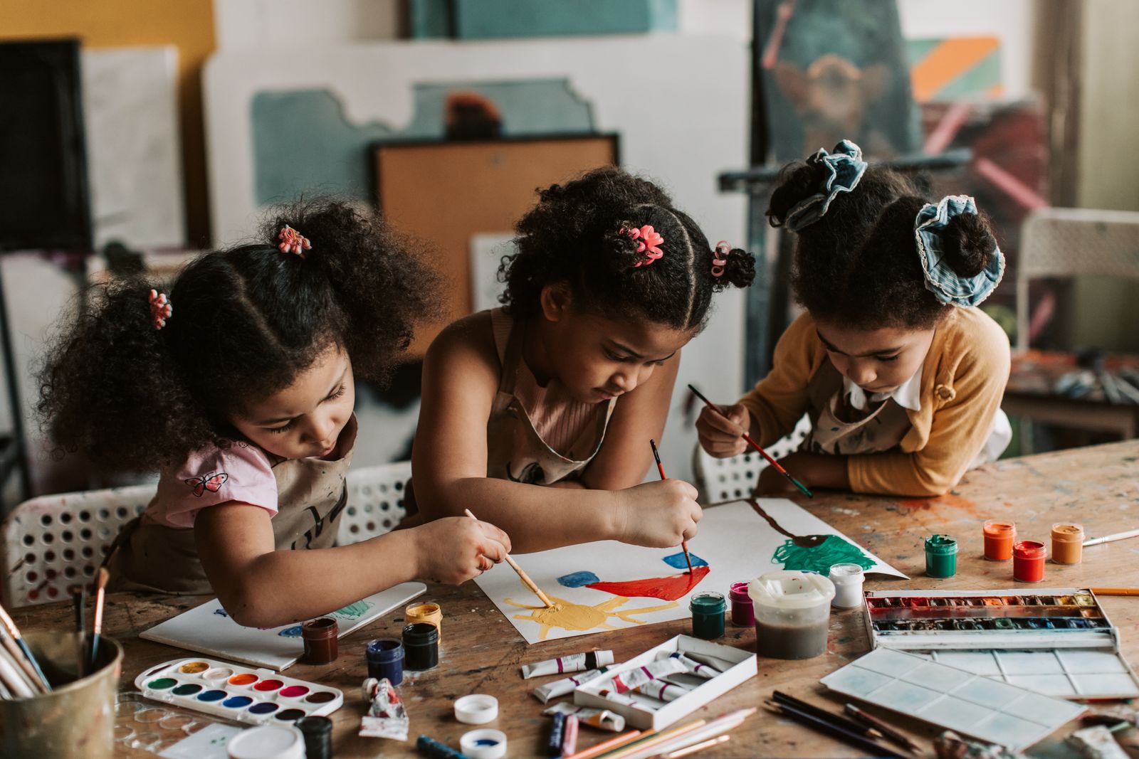 Children painting at an art table during a creativity session.