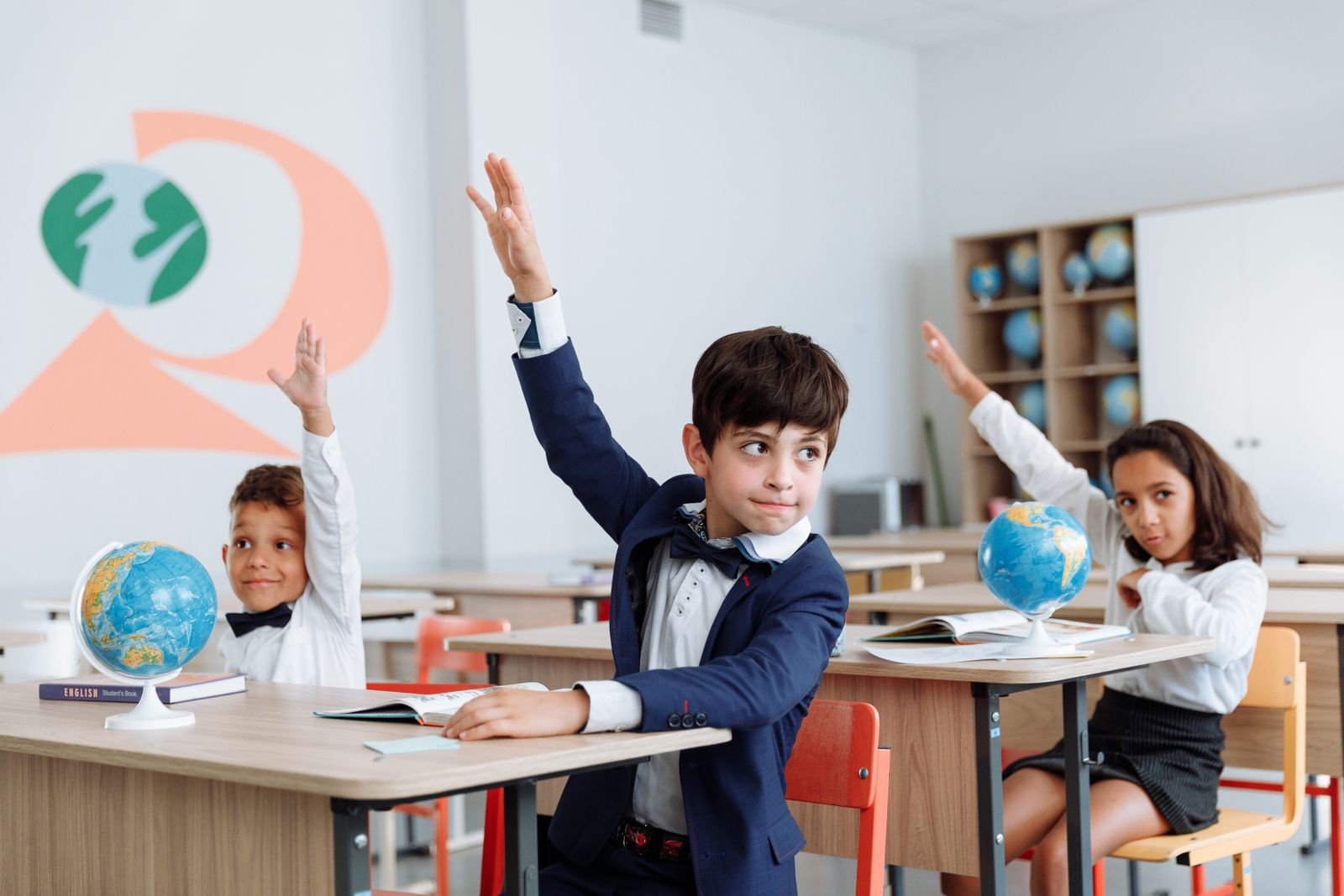 Students eagerly raising their hands during a classroom lesson.