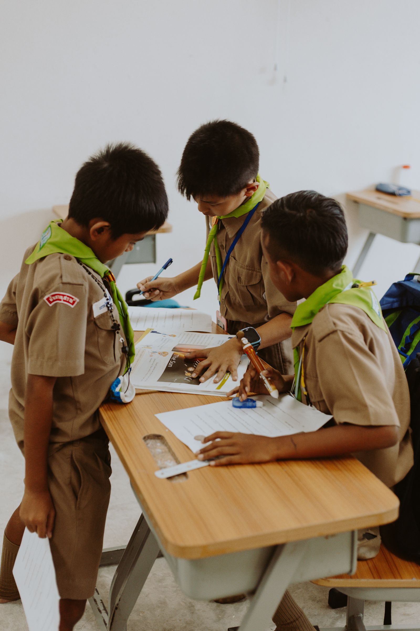 Middle-school students working together at a desk in class.